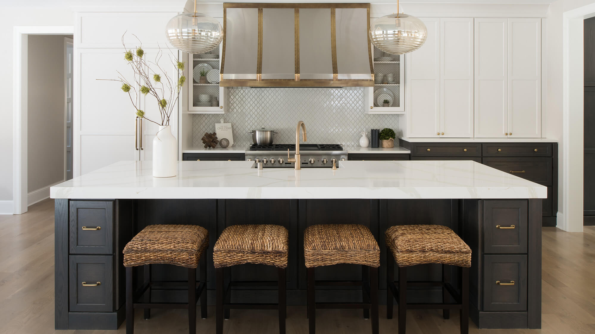 These two-tone kitchen cabinets feature decorative wire mesh cabinet door inserts that add texture and visual interest to the kitchen design. The woven mesh panels complement the two-tone cabinetry while providing a distinctive artisan-inspired detail.
