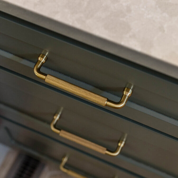 A close up of beautful cabinets with gold cabinet hardware pulls.